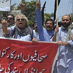 Pakistani journalists denounce censorship, holding a banner that reads: 